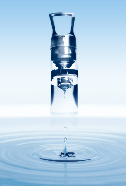 水从水龙头滴下，在浅色背景上飞溅图片下载