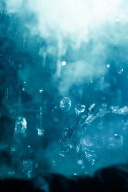 高速照片的小水爆炸与烟雾和溅水珠孤立在黑色背景。图片下载