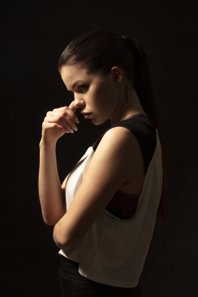 年轻的运动员在黑暗的背景-健身女人的工作室肖像图片下载