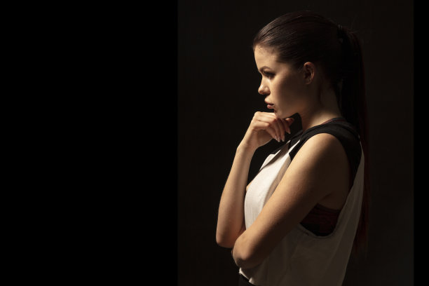 年轻的运动员在黑暗的背景-健身女人的工作室肖像图片下载