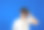 年轻人站在孤立的蓝色背景下，用双筒望远镜望着远方图片下载