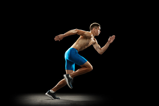 一个白人职业男性运动员，跑步训练孤立在黑暗的工作室背景。肌肉,运动的人。运动的概念，健康的生活方式图片下载