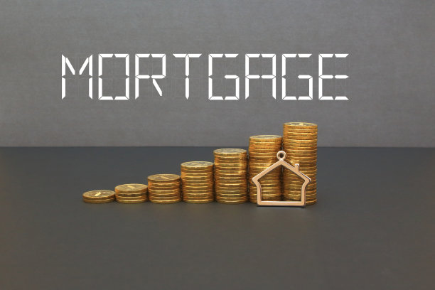台阶硬币堆叠与房屋模型在桌子上。按揭或房产税的概念成像。铭文抵押贷款。图片下载