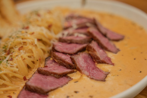 上面有牛排的玫瑰意大利面。图片下载