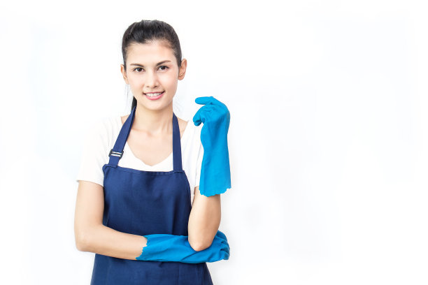 年轻迷人微笑的亚洲家庭主妇的肖像在蓝色围裙与复制空间的白色背景孤立。女管家戴着橡胶手套。清洁工、家庭主妇、工人的生活理念。图片下载
