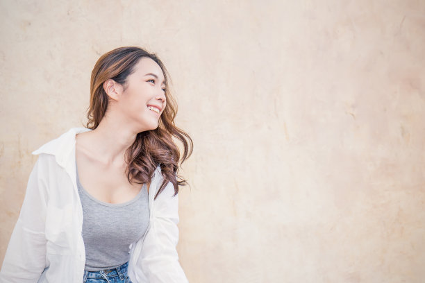 年轻美丽的亚洲女人的肖像坐在和放松的古董墙。微笑快乐的亚洲女孩看着。生活方式人美女邻家概念。图片下载