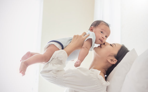 母亲抱着新生儿玩耍，婴儿和母亲说话。健康家庭爱在一起育儿生活motherâ’s day理念图片下载