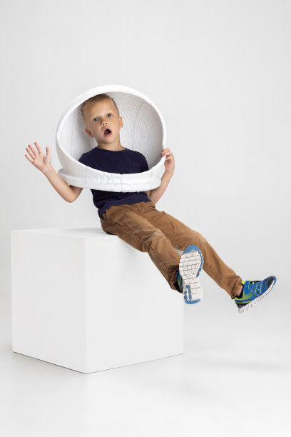 学校男孩的肖像，小学生在大头盔孤立在白色工作室背景。Copyspace广告。童年，教育，情感观念。小的宇航员图片下载