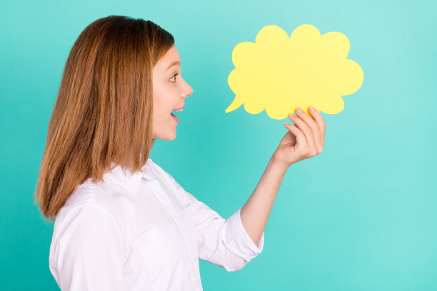 迷人开朗的女孩的侧面画像，手持云复制空间说新闻孤立在明亮的蓝绿色背景图片下载