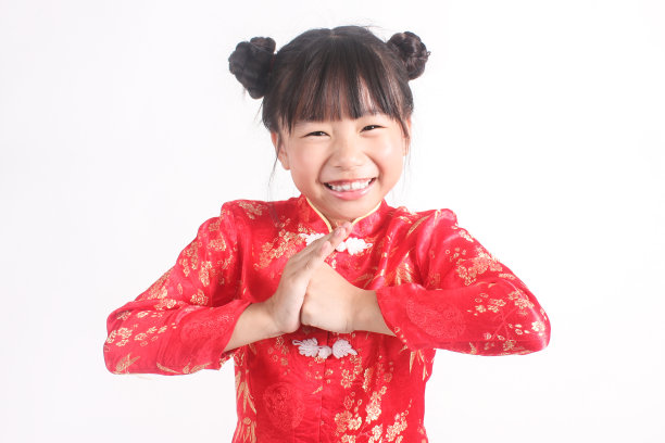 中国东方小女孩祝你新年快乐。小女孩身穿中国红套装，被孤立在白色背景下的特写照片。图片下载