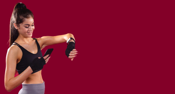 健康快乐的女人一手拿着智能手机发短信，一手拿着智能手表。图片下载