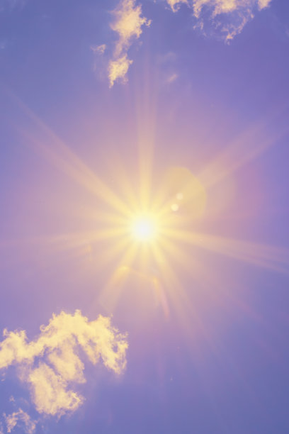 明亮的太阳和美丽的光束在天空中与轻云(色调紫色)图片下载