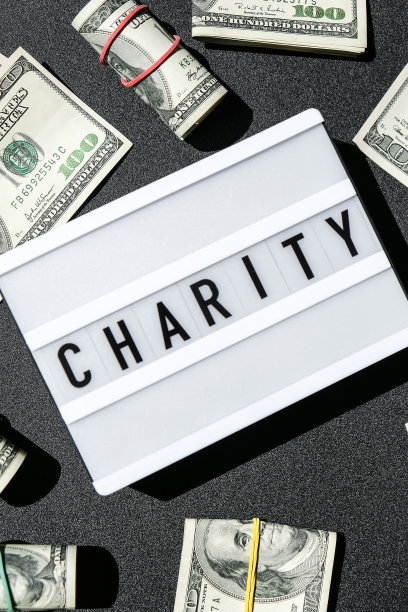 在美元钞票周围有黑字“慈善”字样的灯箱板。金钱，商业，金融，投资，储蓄图片下载