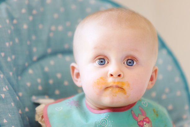 可爱的小女孩喜欢在高脚椅上被喂食和喝水图片下载