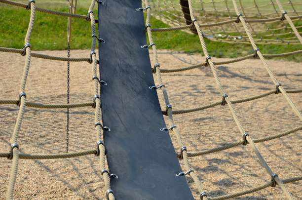 绳麻网通过金属不锈钢接头连接在一个木制框架内。这是操场上吸引孩子们的地方。地上的沙子图片下载