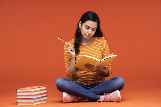 一名年轻女子的肖像在橙色的背景下孤独地坐着图片下载