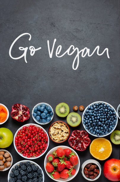 富含抗氧化剂的食物:浆果，坚果，水果。黑色的具体背景。手写题词:成为素食主义者。图片下载