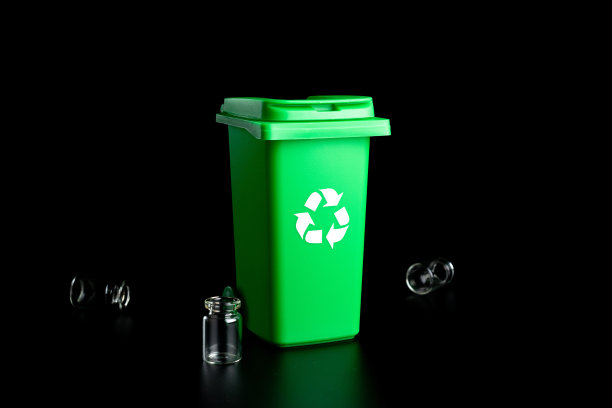 垃圾玻璃。垃圾箱容器用于处理垃圾废物，节约环境。绿色可回收玻璃垃圾箱，可将垃圾隔离在黑色背景上。图片下载