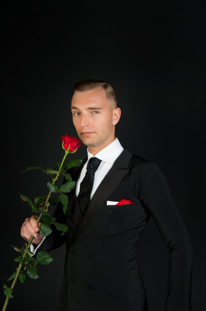 深色背景上有红玫瑰的男人图片下载