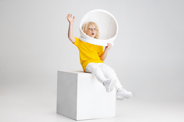 小学前班男孩的肖像在头盔孤立的白色工作室背景。图片下载