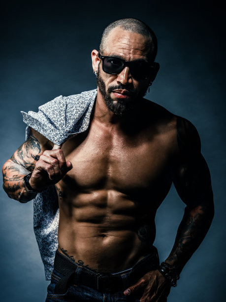 一名肌肉发达的年轻模特在工作室的黑色背景下摆姿势。残暴的古巴人或拉丁美洲人的肖像图片下载