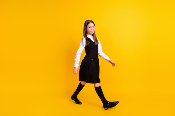 全身大小的照片女学生向前走微笑在统一孤立的亮黄色背景图片下载