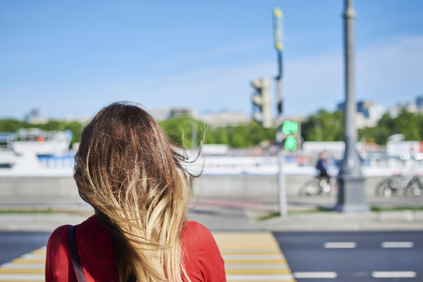 女子的后视图正在穿过城市的人行横道图片下载