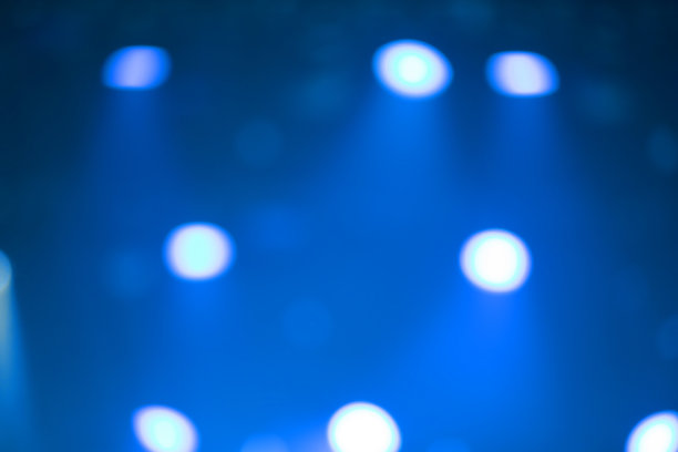 蓝色背景和舞台聚光灯下的白色斑点。图片下载