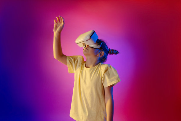 可爱的少女使用VR眼镜在彩色霓虹灯背景图片下载