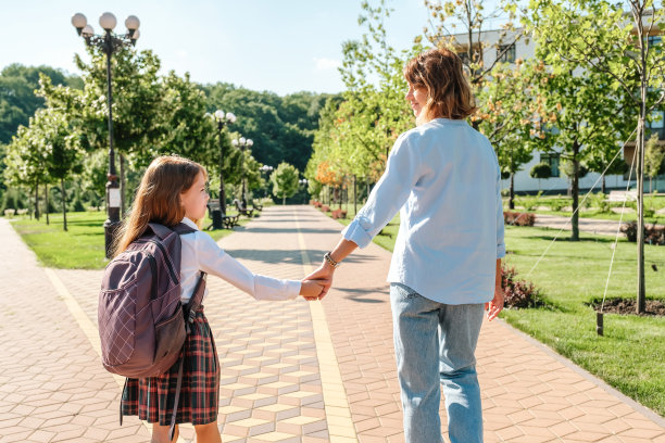 女儿和母亲一起走在街上去上学图片下载