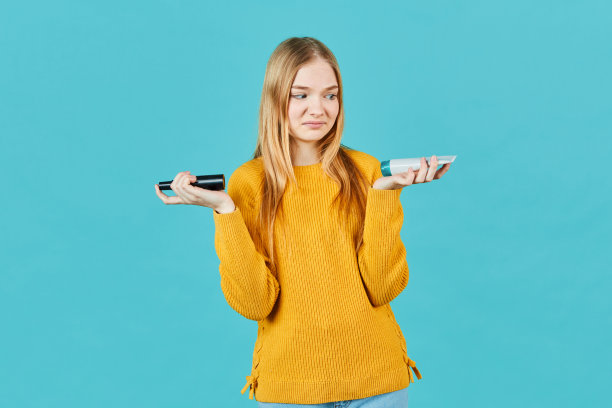 女孩拿着装着化妆品的管子。十几岁的女孩不喜欢润肤霜，油，健康，去角质，去皮霜。图片下载