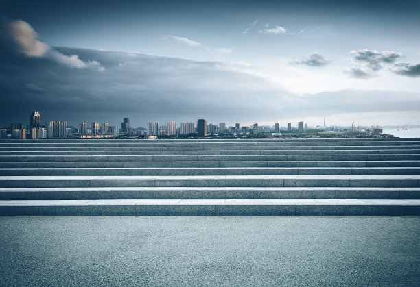 在晴朗的天空下，石阶后面的城市建筑图片下载