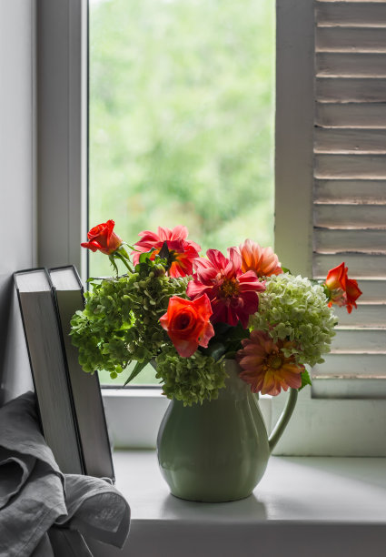 静物——秋天的绣球花和大丽花放在一个复古的陶瓷壶里，书放在有木百叶窗的窗台上图片下载