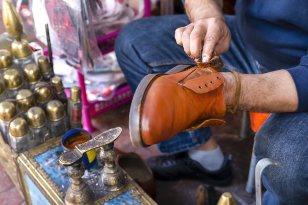 男人在街上用鞋油擦鞋。擦鞋服务。图片下载
