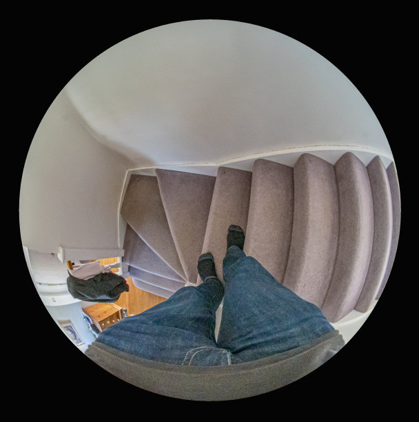 鱼眼镜头图像向下看的脚在楼梯上。图片下载