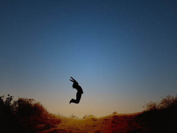 女孩在海滩上跳跃图片下载