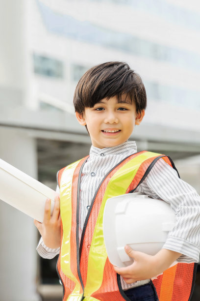 小男孩戴着白色头盔，手里拿着图纸草图图片下载