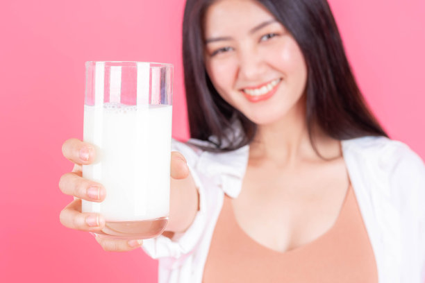 美丽女人亚洲可爱的女孩感到快乐喝牛奶为健康在早上粉红色的背景-生活方式的美丽女人图片下载