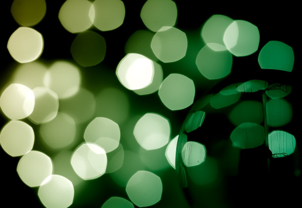 摘要离焦背景上的绿色光效果与灯泡上的前景。图片下载