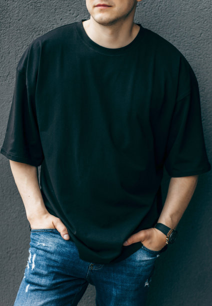 男人穿着黑色的空白t恤，上面有你的标志或设计的空间。模拟了图片下载