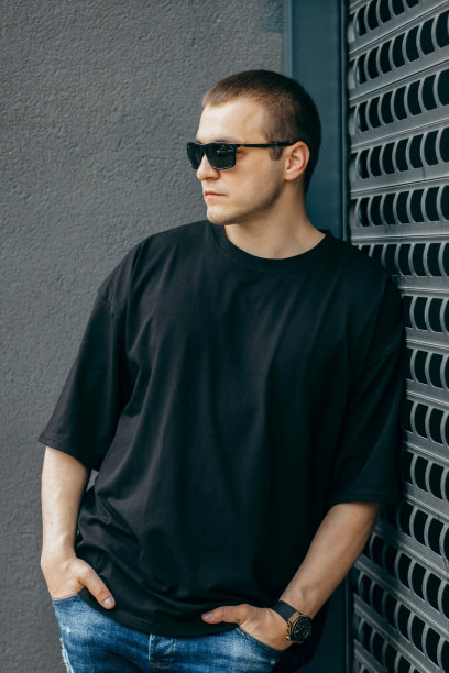 男人穿着黑色的空白t恤，上面有你的标志或设计的空间。模拟了图片下载