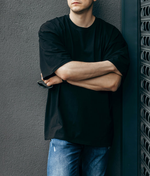 男人穿着黑色的空白t恤，上面有你的标志或设计的空间。模拟了图片下载