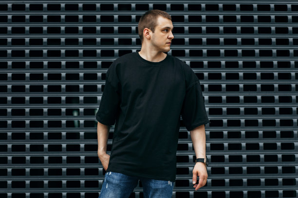 男人穿着黑色的空白t恤，上面有你的标志或设计的空间。模拟了图片下载