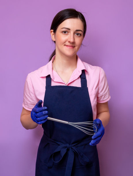 一位女糕点师双手拿着厨房打蛋器。有选择性的重点。图片下载