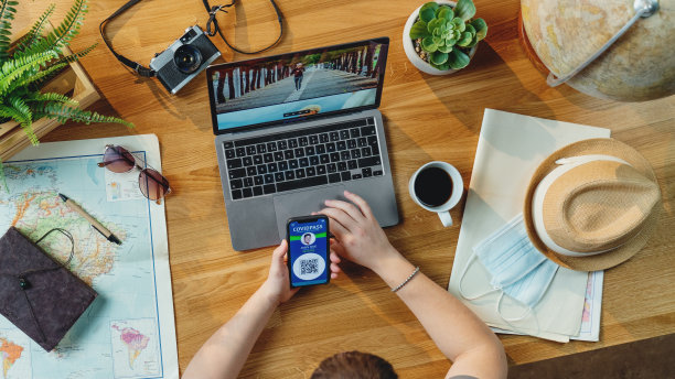 俯视图年轻人用笔记本电脑规划度假旅行，桌面旅行新冠概念图片下载