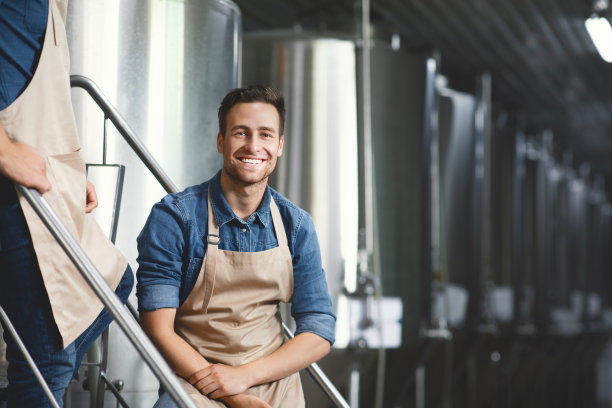 现代啤酒厂老板，在酒精饮料工厂的工人，啤酒厂的工作场所图片下载