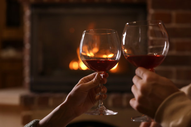可爱的夫妇在室内壁炉旁喝酒，特写镜头。寒假图片下载