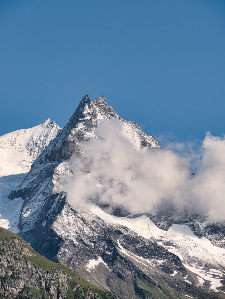 在奔宁阿尔卑斯山脉的贝索峰，雪和云，与蓝色的天空图片下载