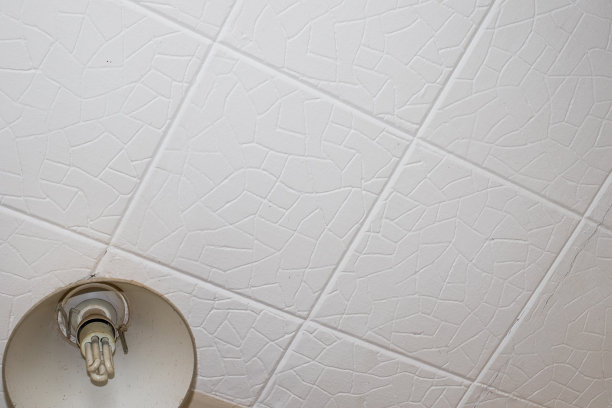 旧的聚苯乙烯天花板瓷砖。危险家居火灾隐患。图片下载