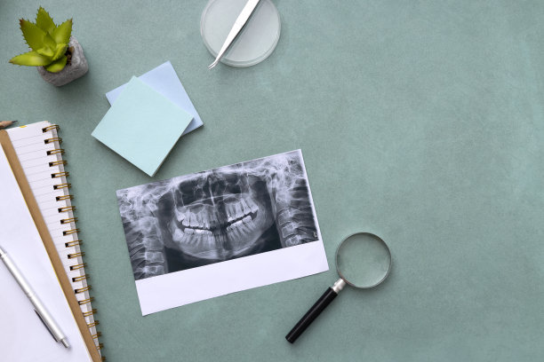 牙齿的x光俯视图，放大镜，笔记本，蓝色牙医桌上的办公纸。空的空间图片下载